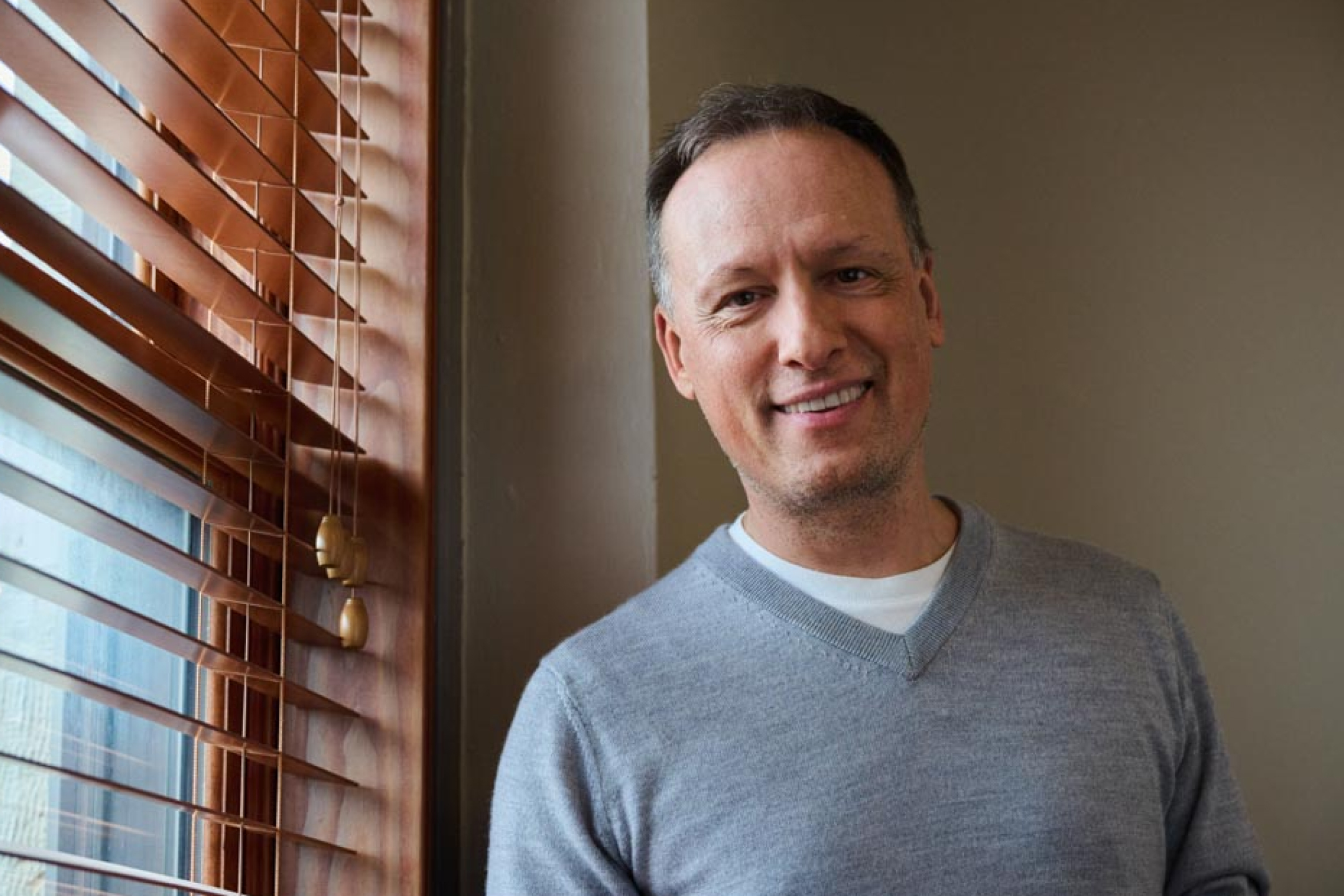 Smiling man by a window, symbolizing confidence in CREF variable annuities